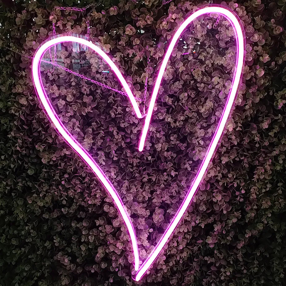 A pink heart shaped neon sign
